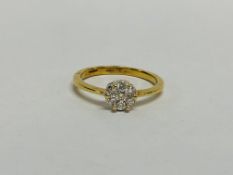 18CT GOLD DIAMOND FLOWER HEAD RING SET WITH 7 SMALL STONES.