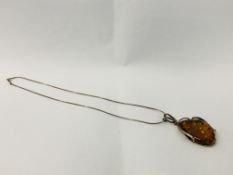 DESIGNER SILVER AND AMBER PENDANT ON A SILVER CHAIN.