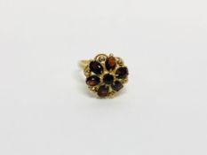 IMPRESSIVE 9CT GOLD RING SET WITH 7 RUBY COLOURED STONES.