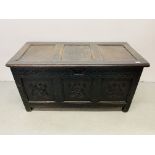 AN ANTIQUE OAK COFFER WITH HAND CARVED PANELS AND RAIL W 125CM, D 59CM, H 66CM.