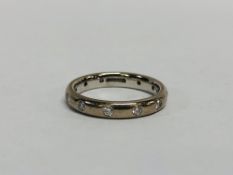 18CT WHITE GOLD WEDDING BAND SET WITH 11 SMALL DIAMONDS (1 MISSING).