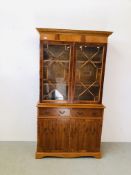 A REPRODUCTION YEW WOOD FINISH ASTRAGAL GLAZED BOOKCASE STANDING ON TWO DRAWER CABINET BASE W 105CM,