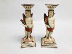 PAIR OF PEARLWARE CANDLESTICKS IN THE FORM OF A WINGED CHERUB HOLDING A CLUB, C.