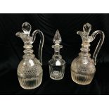 PAIR OF EARLY C19TH WINE JUGS THE LOOP HANDLES ON A CUT GLASS BODY BOTH WITH CRACKS IN RING NECK