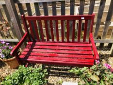 A RED PAINTED GARDEN BENCH.