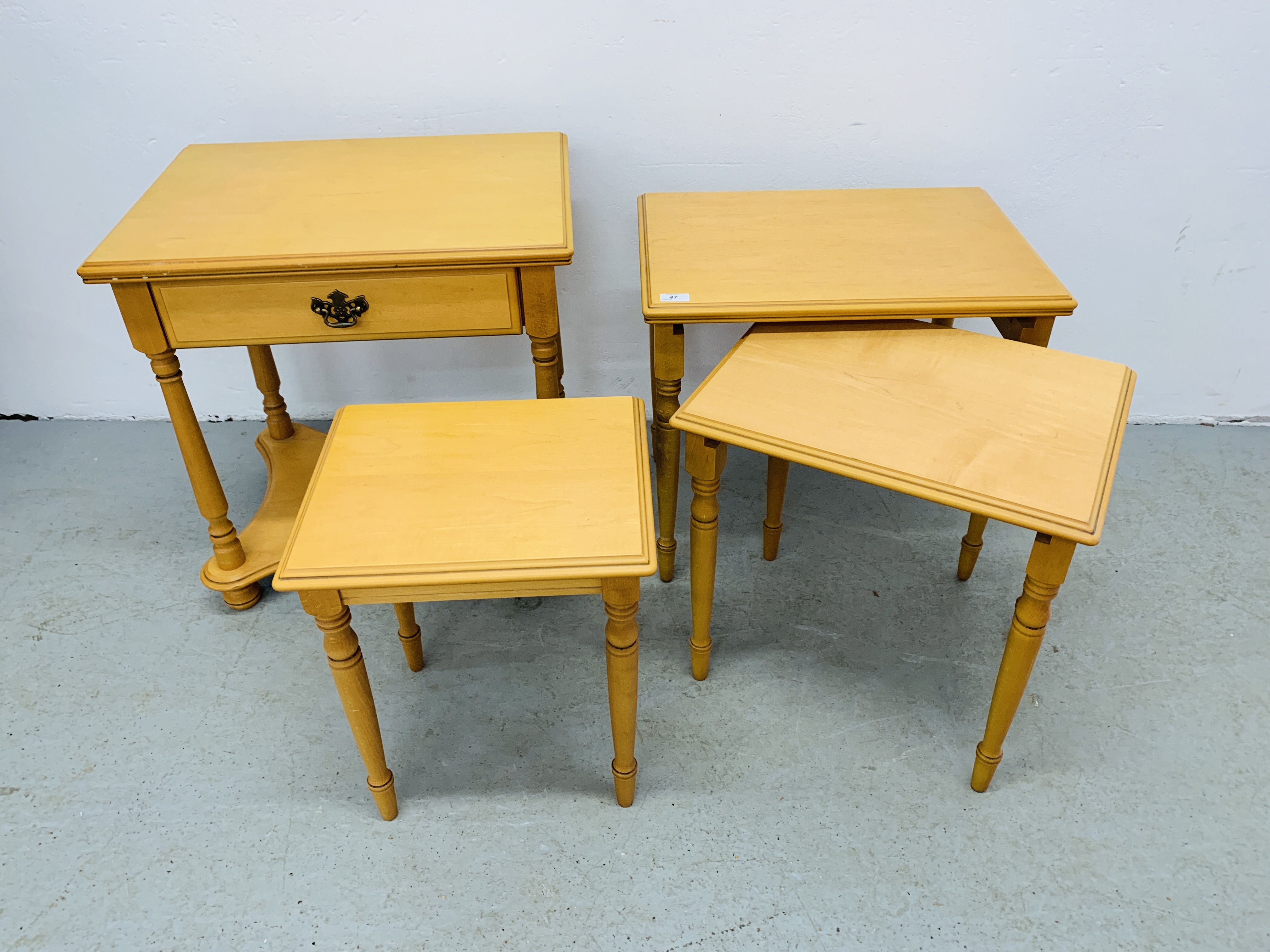 A NEST OF 3 MODERN BEECHWOOD FINISH TABLES AND MATCHING SINGLE DRAWER TABLE WITH SHELF BELOW.