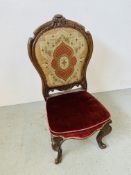 A VICTORIAN SIMULATED ROSEWOOD NURSING CHAIR, THE BACK RETAINING THE ORIGINAL NEEDLEWORK,