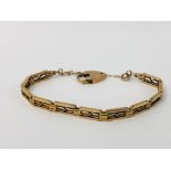 YELLOW METAL FANCY LINK BRACELET WITH 9CT GOLD PADLOCK AND SAFETY CHAIN.