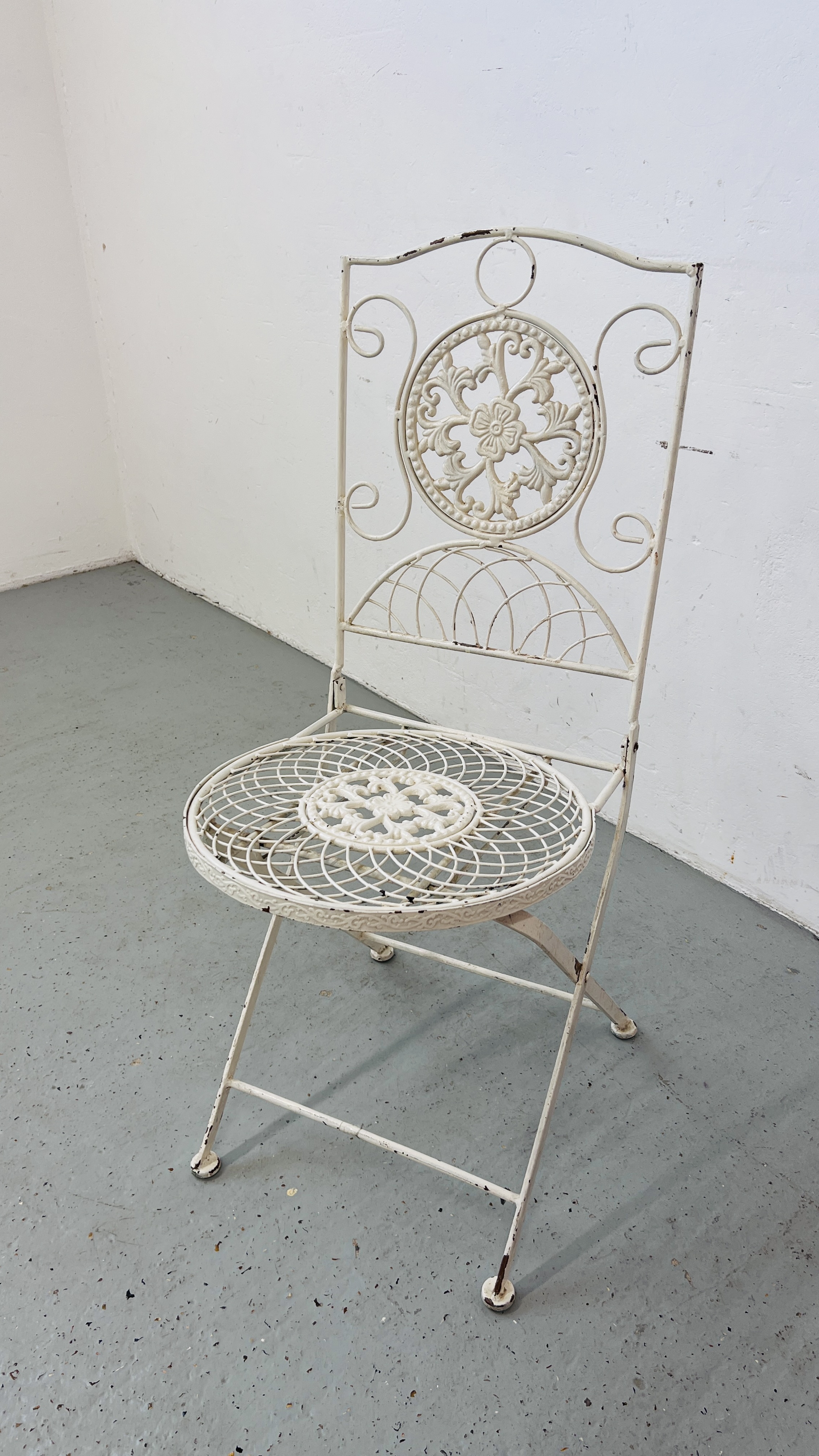 A WHITE PAINTED DECORATIVE FOLDING METALCRAFT GARDEN CHAIR.