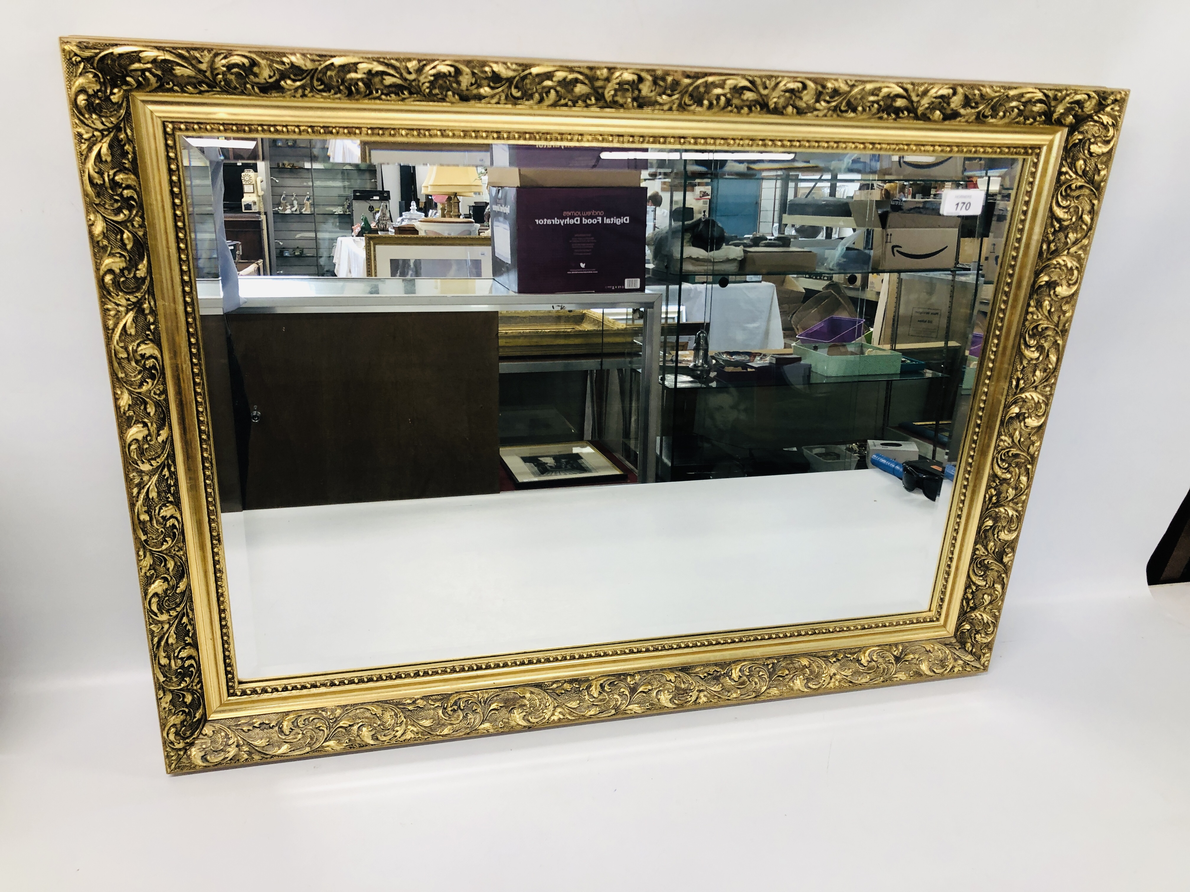 A GILT FRAMED WALL MIRROR WITH BEVELLED PLATE GLASS 60CM X 85CM.