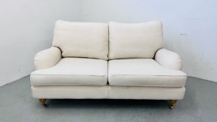 A MODERN CREAM LINEN UPHOLSTERED TWO SEATER SOFA LENGTH 160CM.