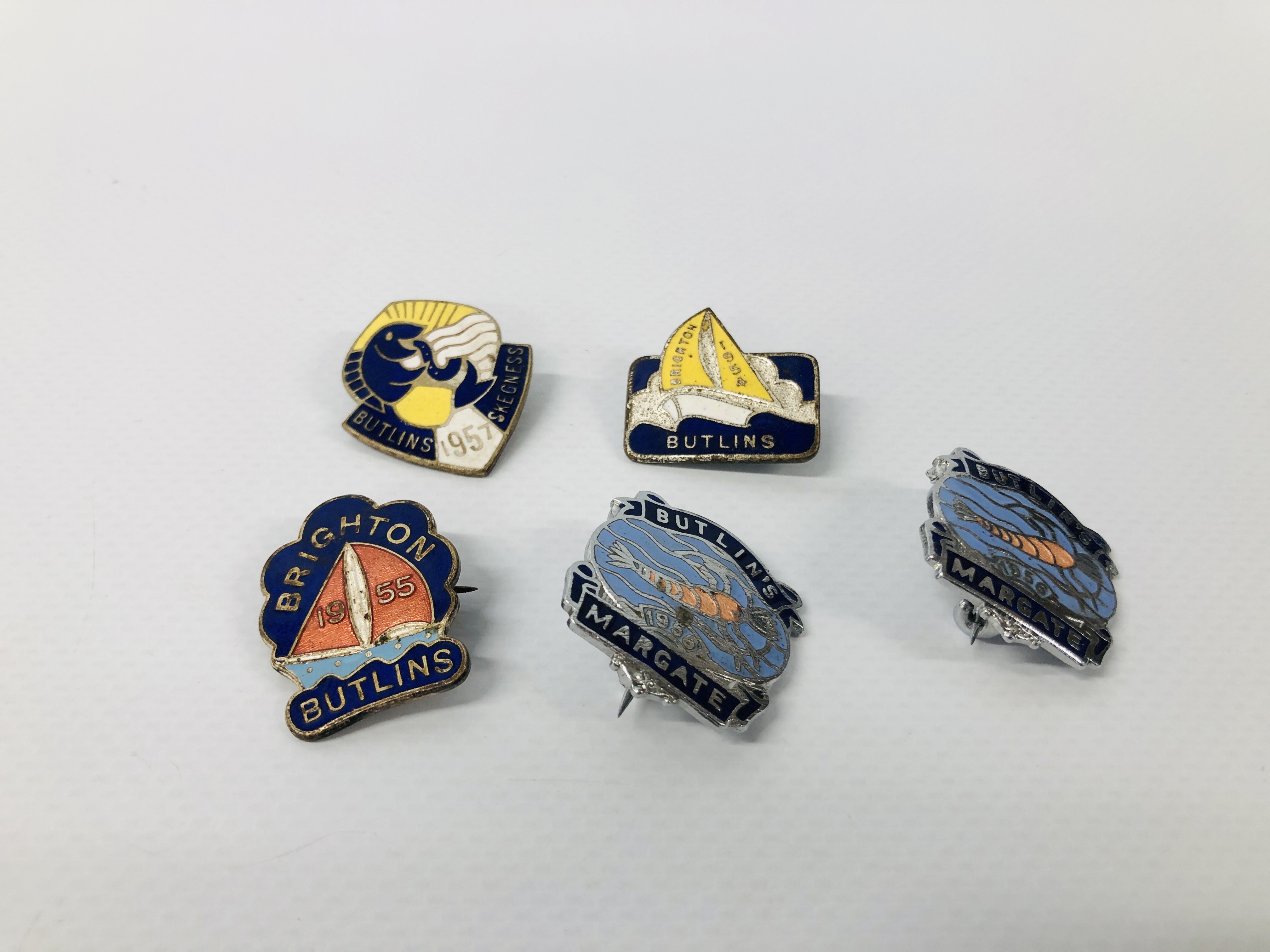 FIVE VINTAGE ENAMELLED BUTLINS BADGES TO INCLUDE MARGATE, 1957 SKEGNESS, 1955 AND 1954 BRIGHTON,