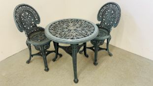 A DECORATIVE CAST IRON EFFECT PATIO TABLE AND TWO CHAIRS