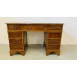 A REPRODUCTION YEW WOOD FINISH TWIN PEDESTAL DESK, THE TOP WITH GREEN TOOLED LEATHERETTE W 122CM,