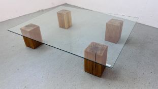 AN EXTRA LARGE GLASS TOP COFFEE TABLE SUPPORTED BY FOUR SOLID OAK BLOCKS 153CM X 122CM.
