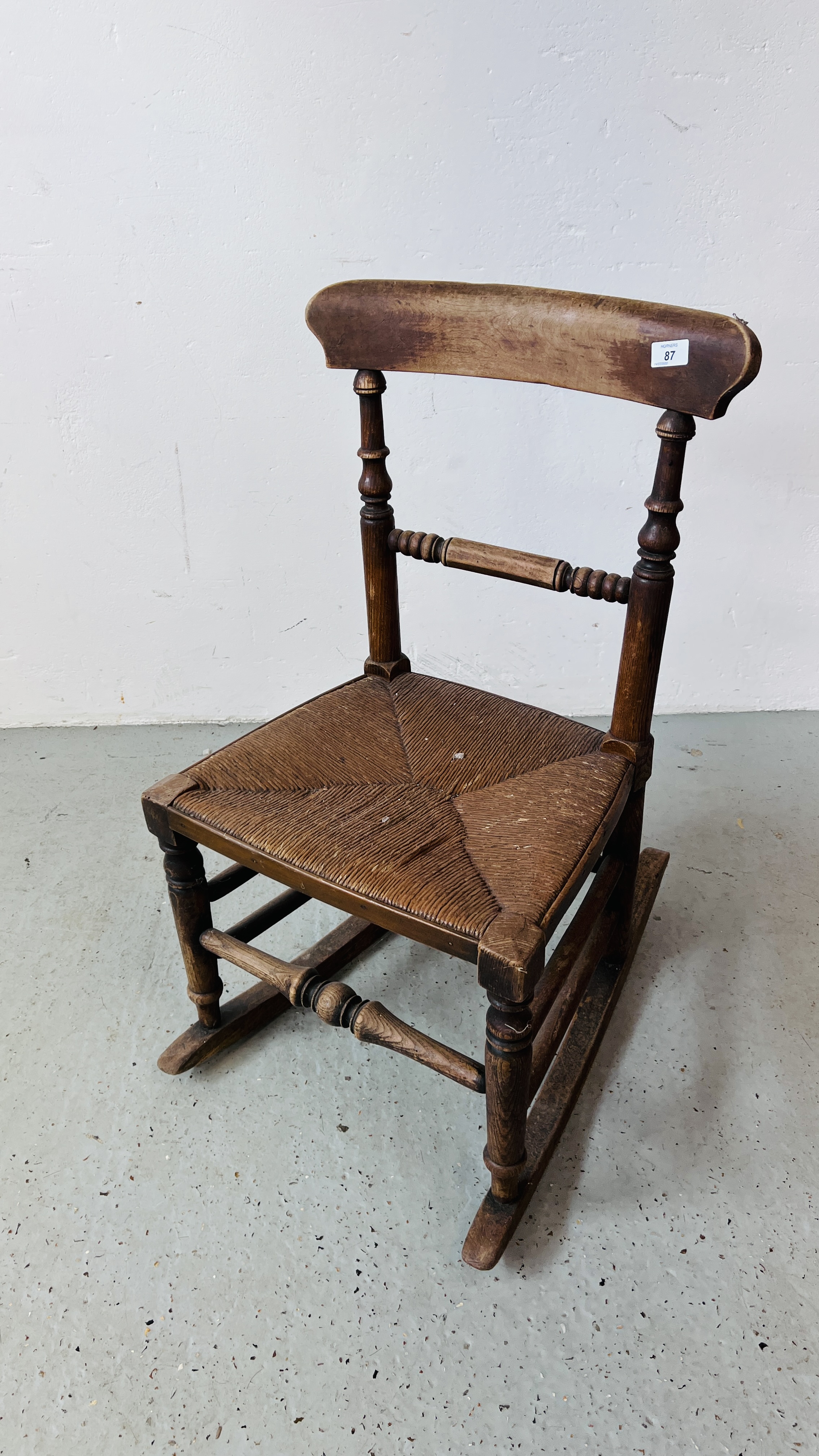 VICTORIAN OAK ROCKING CHAIR WITH REEDED SEAT.