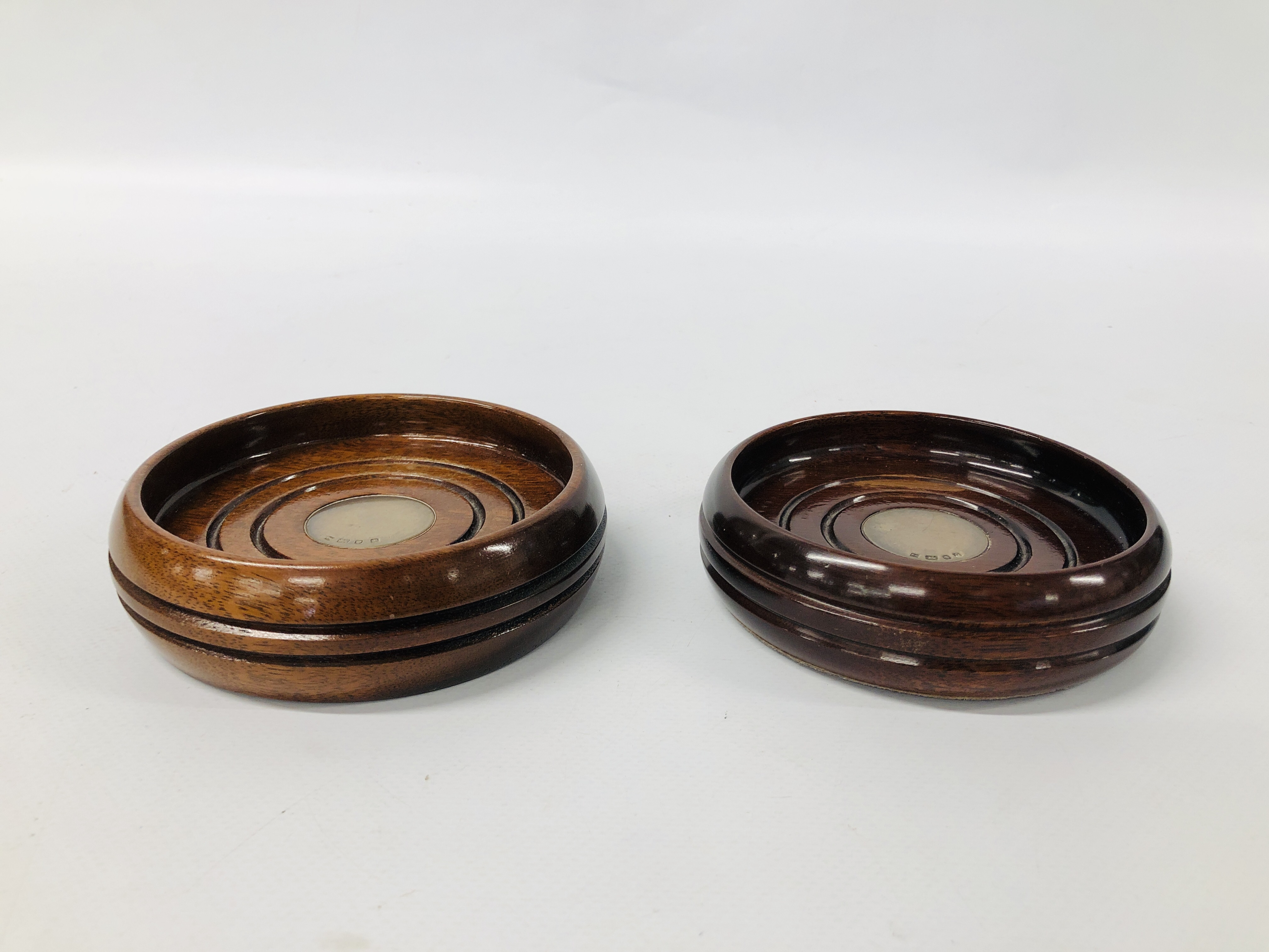 PAIR OF MAHOGANY WINE COASTERS WITH SILVER DISC INSERTS.