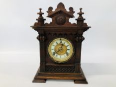 A DECORATIVE OAK CASED MANTEL CLOCK WITH CARVED DETAIL AND PENDULUM H 38CM.