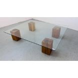 AN EXTRA LARGE GLASS TOP COFFEE TABLE SUPPORTED BY FOUR SOLID OAK BLOCKS 153CM X 122CM.
