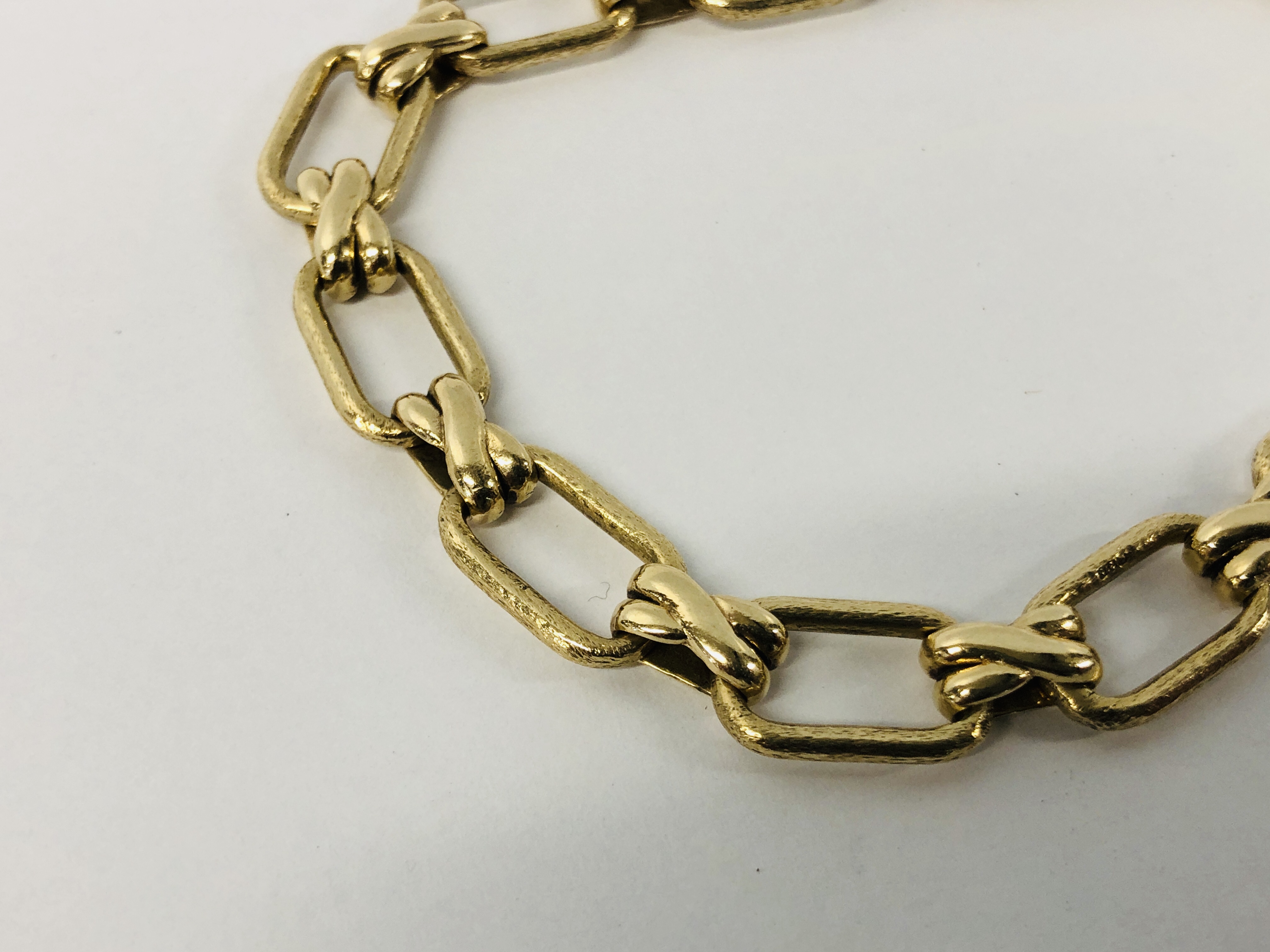 ELEGANT 9CT GOLD FLAT LINK BRACELET WITH A CROSS OVER DESIGN. - Image 3 of 8