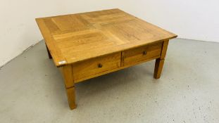 A SOLID OAK TWO DRAWER COFFEE TABLE W 100CM, D 100CM, H 46CM.