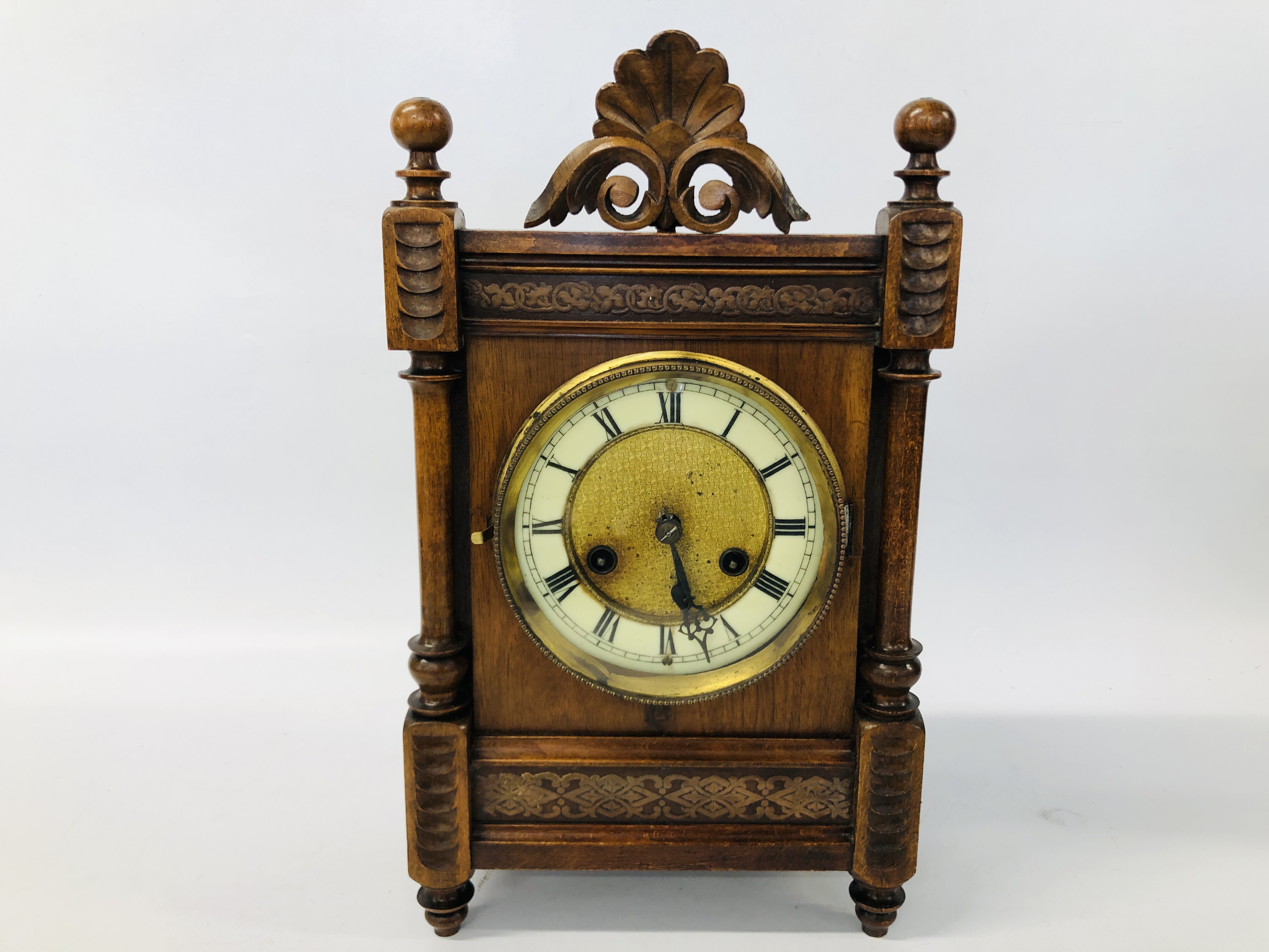 A OAK CASED MANTEL CLOCK WITH CARVED DETAIL AND PENDULUM H 39CM.