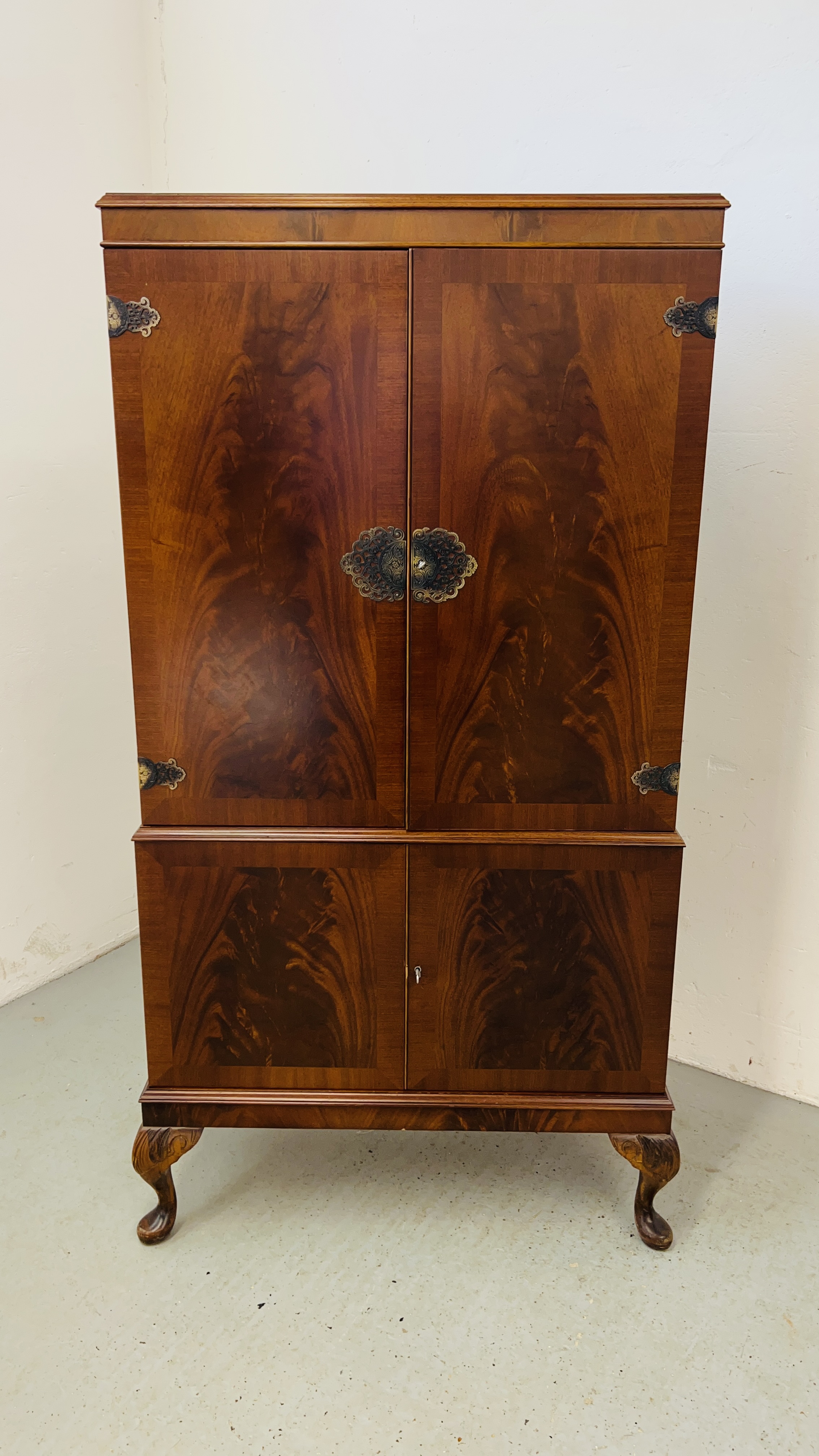 A GOOD QUALITY REPRODUCTION MAHOGANY FINISH DRINKS CABINET WITH MIRRORED INTERIOR STANDING ON