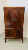 A GOOD QUALITY REPRODUCTION MAHOGANY FINISH DRINKS CABINET WITH MIRRORED INTERIOR STANDING ON