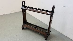 AN ANTIQUE OAK STICK STAND WITH FIDDLEWORK DETAILING AND HOOPED ENDS,