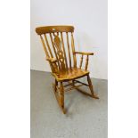 A SOLID BEECHWOOD WINDSOR STYLE ROCKING CHAIR
