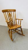 A SOLID BEECHWOOD WINDSOR STYLE ROCKING CHAIR