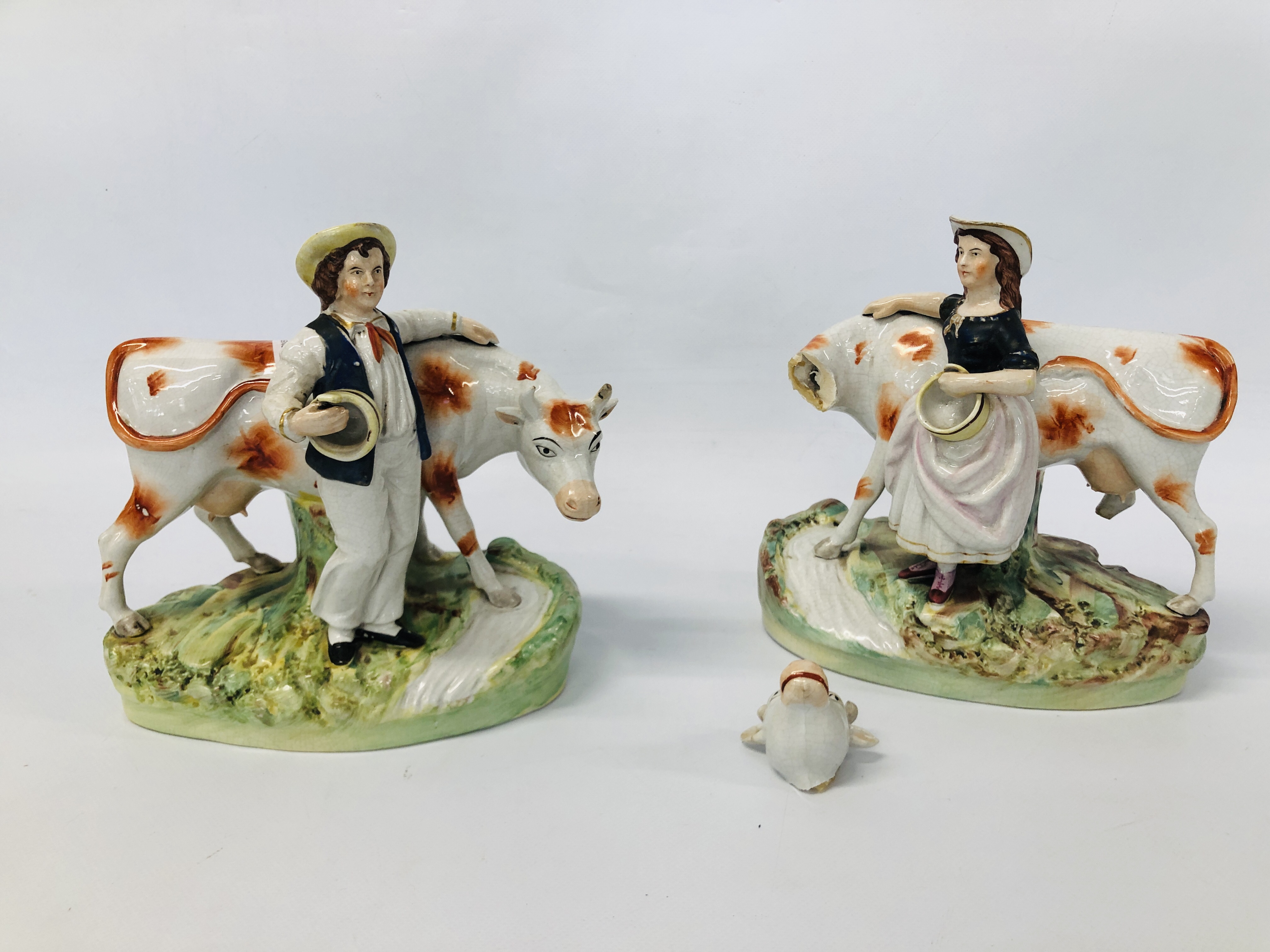 PAIR OF STAFFORDSHIRE TYPE FIGURES OF A MILK MAID AND A BOY STANDING BY A COW A/F HEIGHT 21CM.