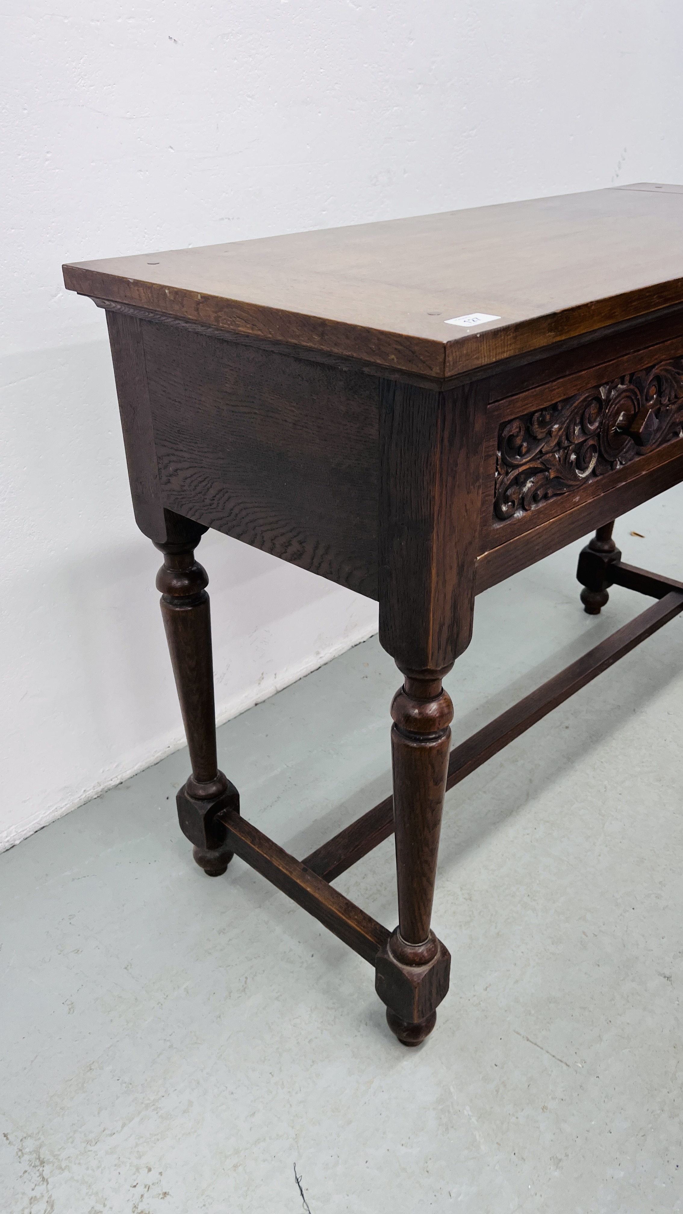 A REPRODUCTION SOLID OAK TWO DRAWER SIDE TABLE WITH CARVED DRAWER FRONTS W 107CM, D 46CM, H 77CM. - Image 3 of 9