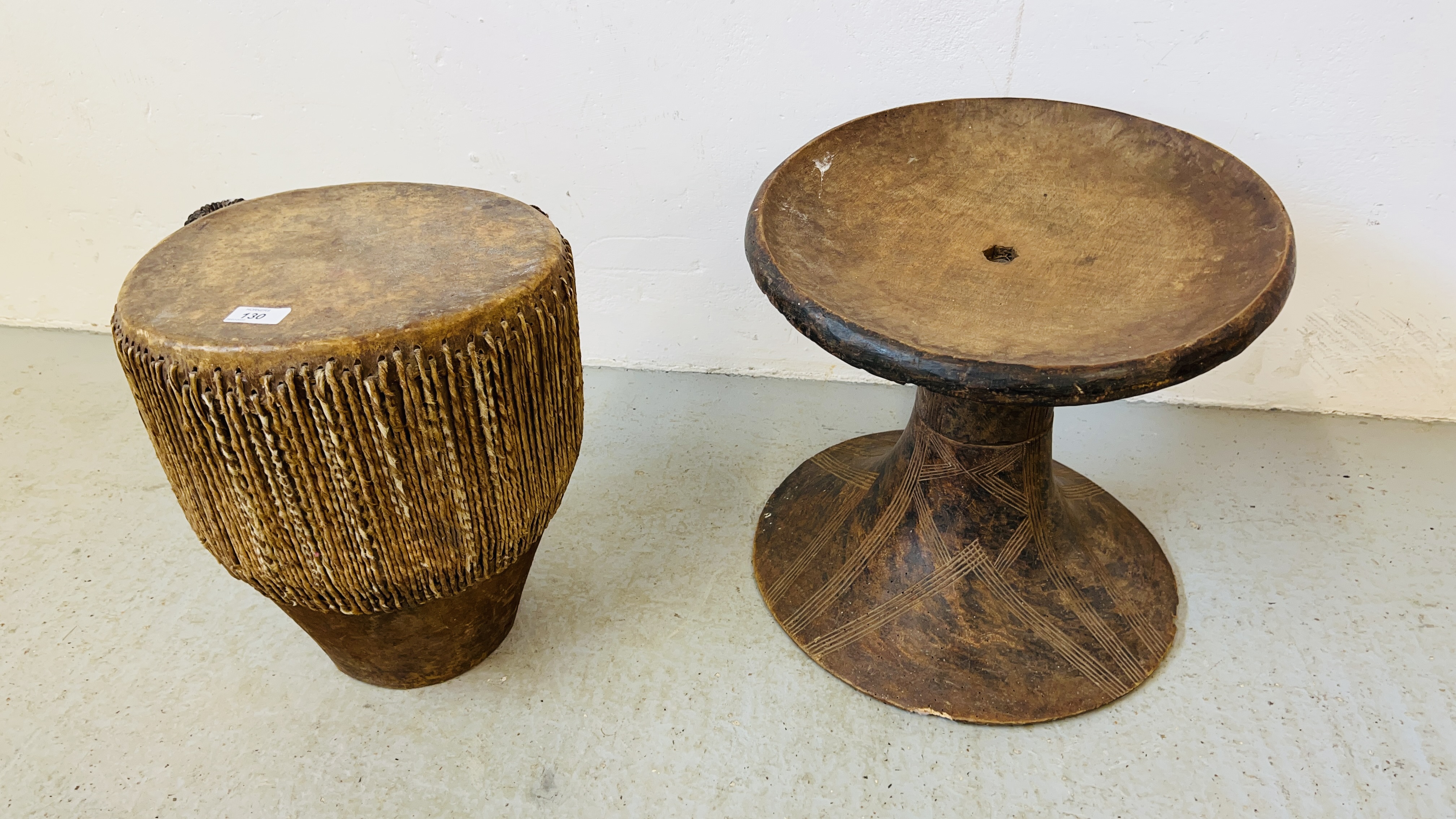 AN AFRICAN SKIN DRUM AND HAND CARVED AFRICAN STAND H 37CM, D 41CM.