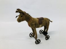 AN ANTIQUE STEIFF DONKEY ON WHEELS (HEIGHT TO TOP OF HEAD, 13.5CM).