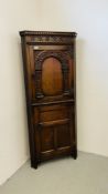 A REPRODUCTION OAK FLOOR STANDING TWO DOOR CORNER CABINET WITH SHELVED INTERIOR W 69CM H 161CM.