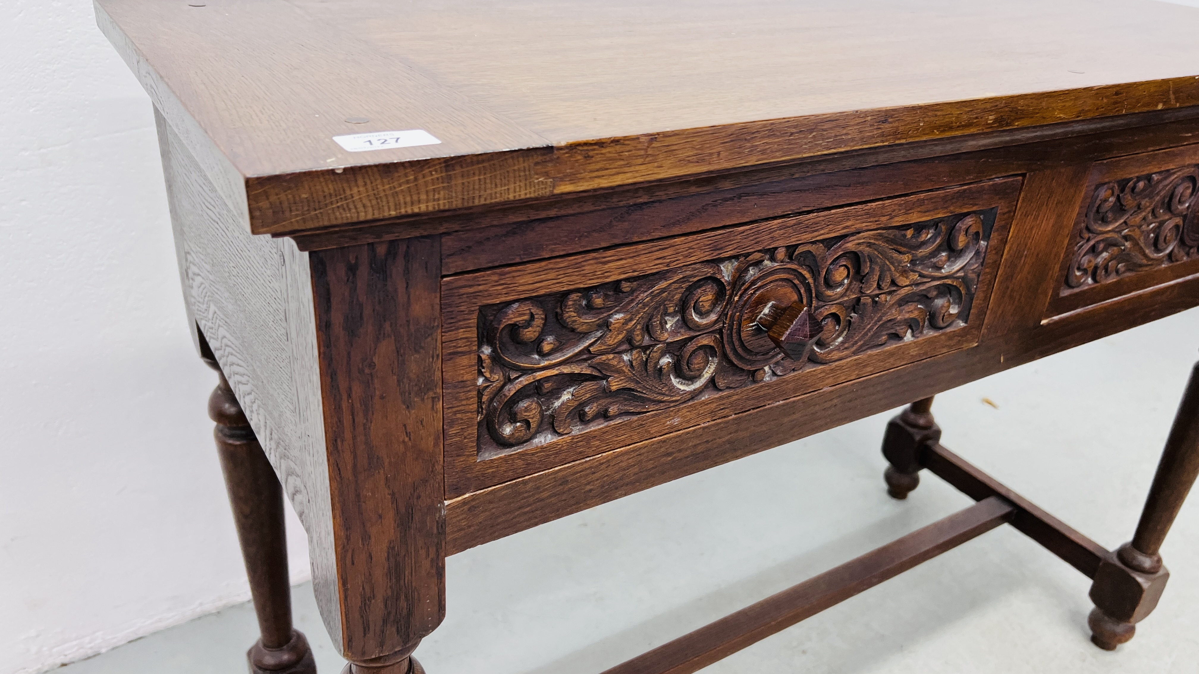 A REPRODUCTION SOLID OAK TWO DRAWER SIDE TABLE WITH CARVED DRAWER FRONTS W 107CM, D 46CM, H 77CM. - Image 4 of 9