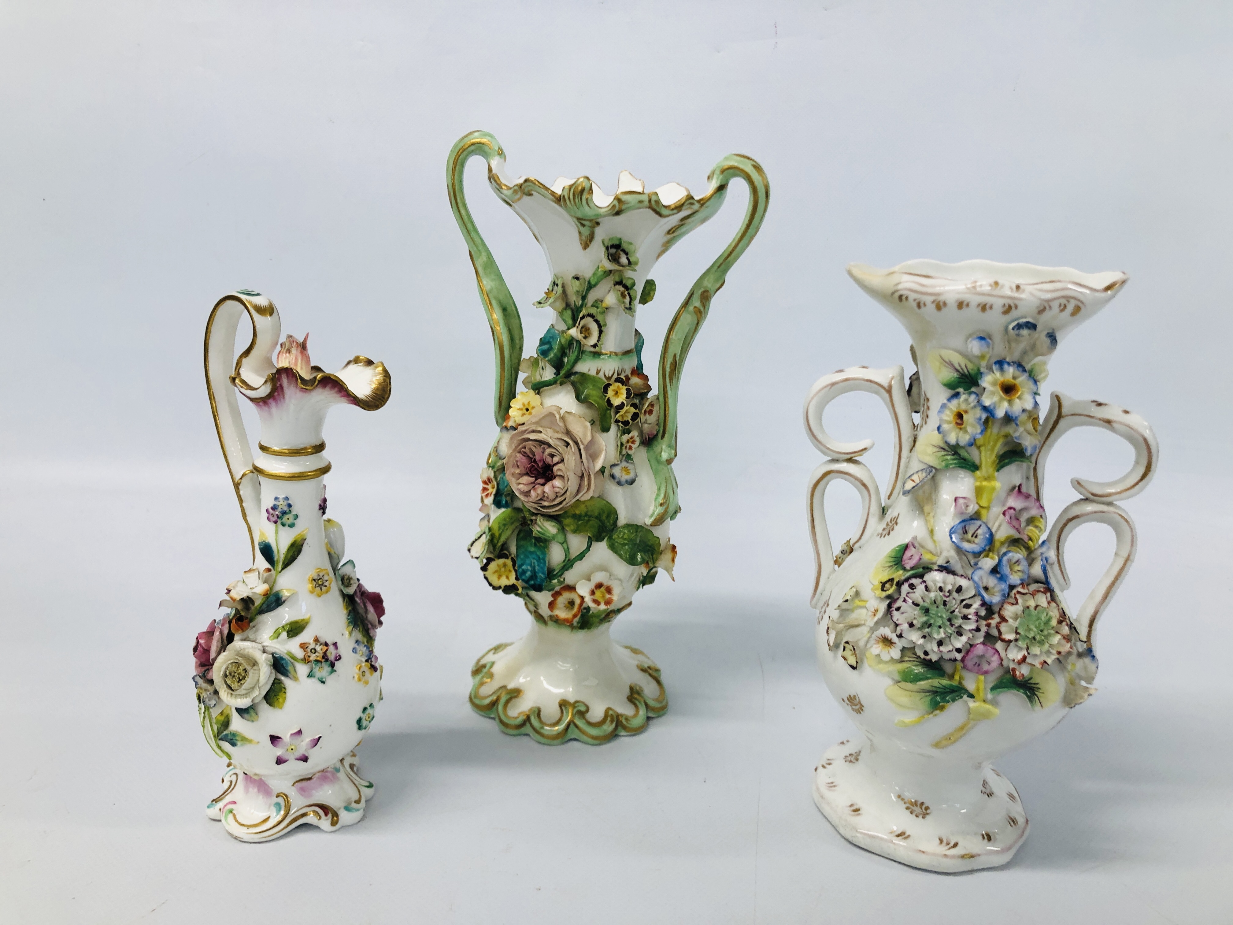 TWO C19TH STAFFORDSHIRE FLOWER ENCRUSTED TWO HANDLED VASES (ONE WITH RESTORED TOP THE OTHER WITH