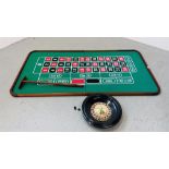 A LARGE TABLE TOP ROULETTE BOARD AND ROULETTE WHEEL AND STICK