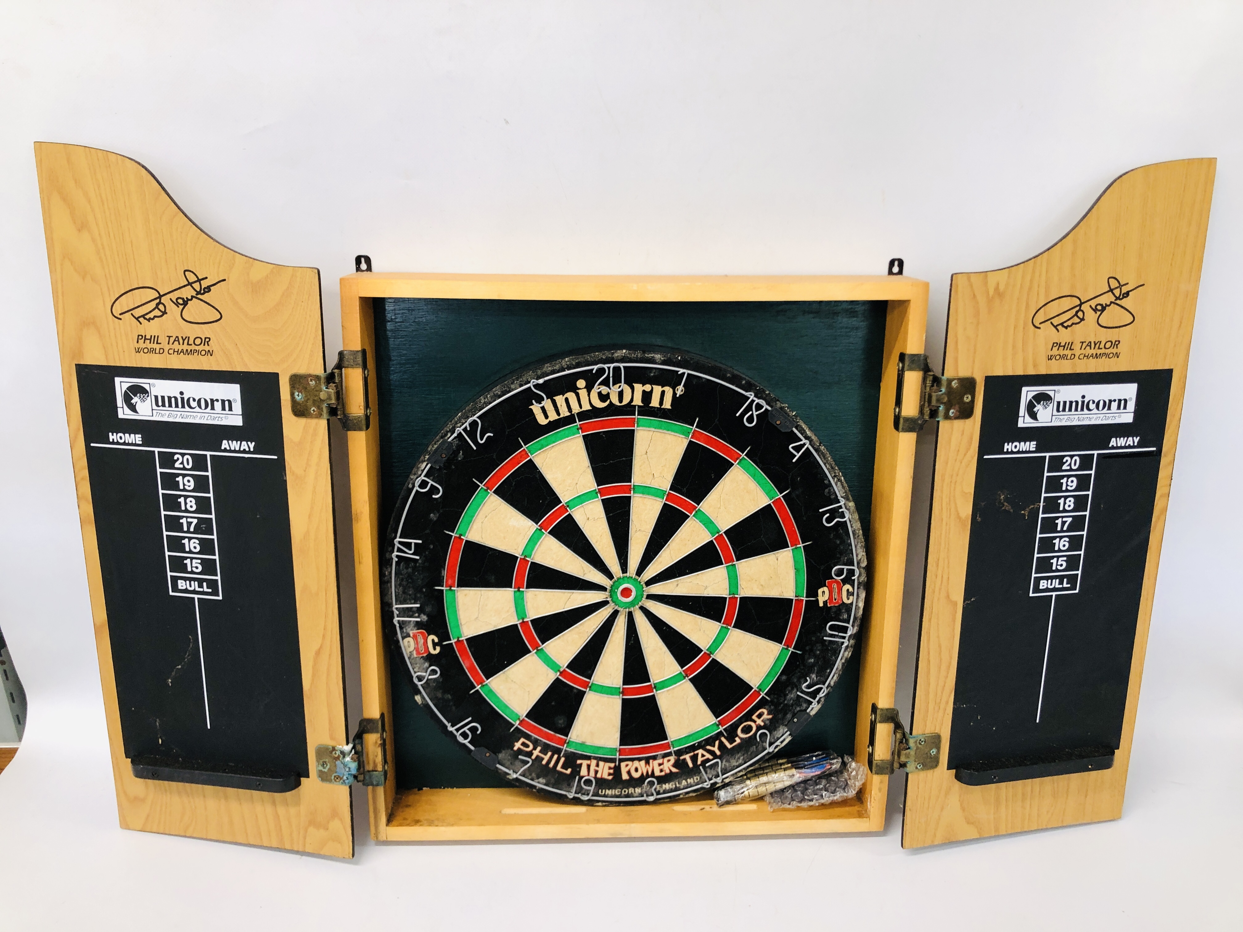 A CABINET MOUNTED UNICORN DARTBOARD BY PHIL TAYLOR.
