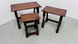 A NEST OF THREE REPRODUCTION GOOD QUALITY OAK TABLES (THE LARGEST 60CM. X 32CM.