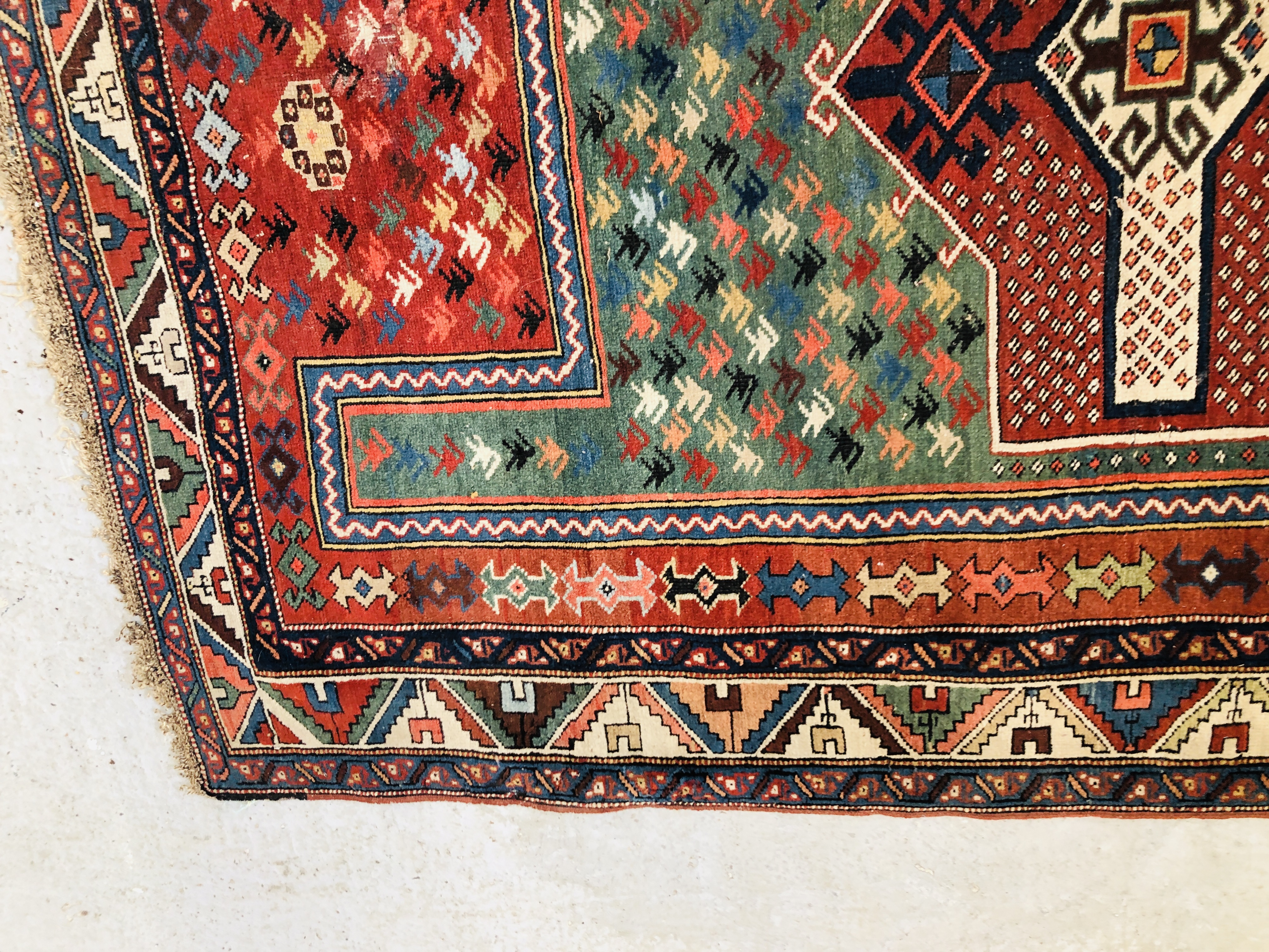 A CAUCASIAN PRAYER RUG THE MIHRAB HAVING A GREEN FIELD FILLED WITH HOOKED MOTIFS AROUND A SECONDARY - Image 4 of 6