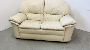 A CREAM LEATHER TWO SEATER SOFA.