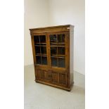A GOOD QUALITY REPRODUCTION OAK TWO DOOR GLAZED DISPLAY CABINET ON TWO DOOR CUPBOARD BASE W 97CM,