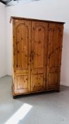 A GOOD QUALITY HONEY PINE TRIPLE DOOR WARDROBE WIDTH 137 CM. DEPTH 56CM. HEIGHT 190CM.