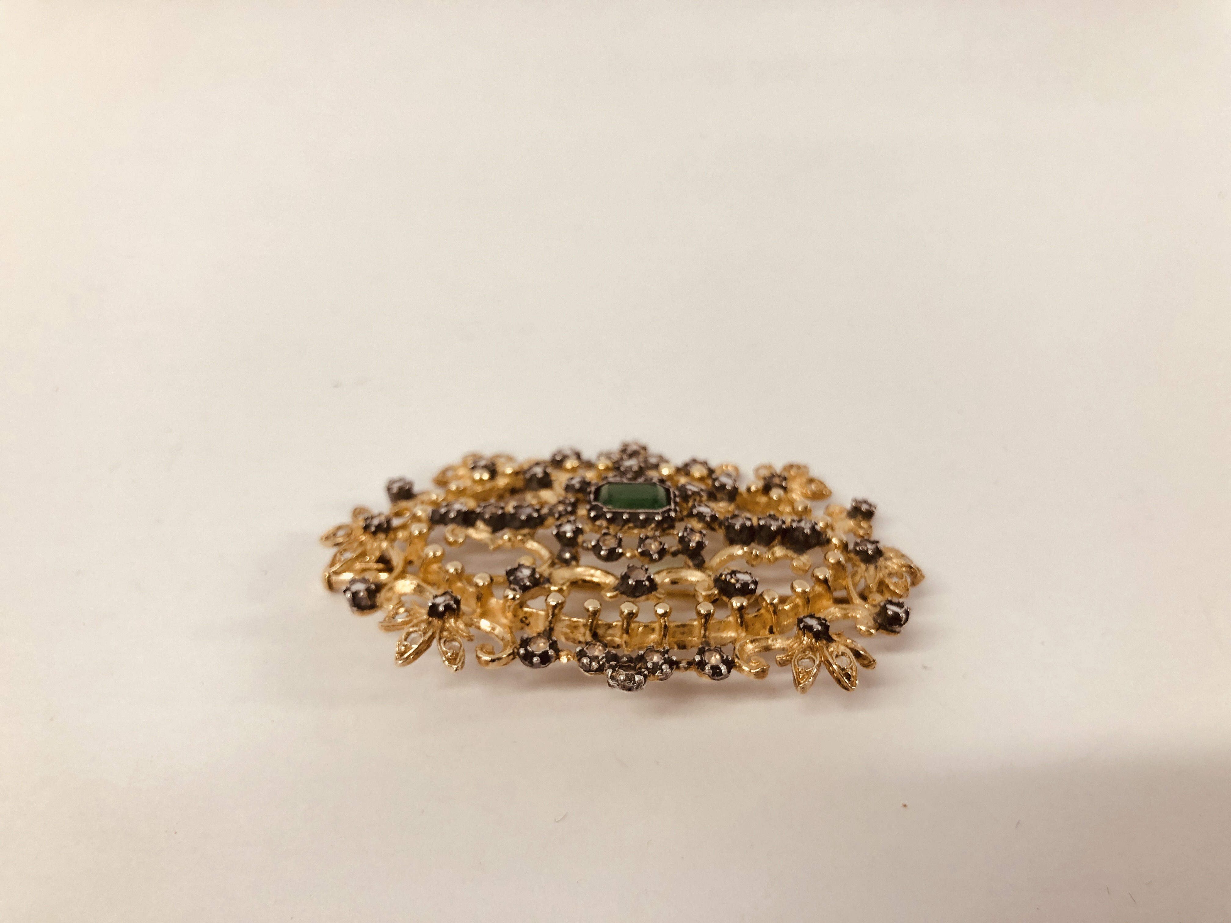 DESIGNER GILT BROOCH SET WITH CENTRAL GREEN STONE AND MULTIPLE CLEAR STONES, MARKED "ART JOY". - Image 4 of 5