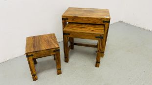 A NEST OF THREE MANGO WOOD GRADUATED TABLES.