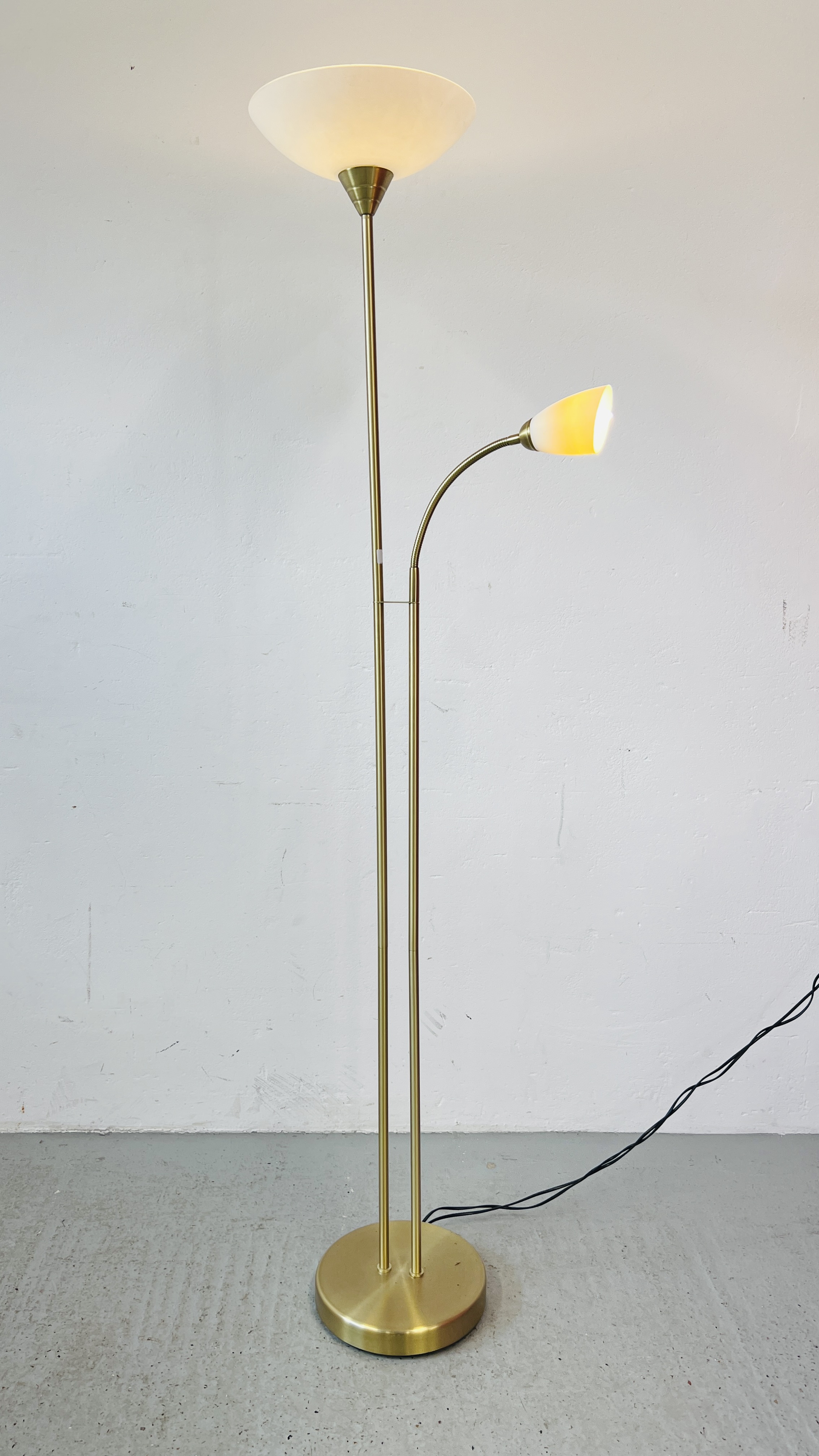 A BRASS FINISH UPLIGHTER WITH ADJUSTABLE READING LIGHT - SOLD AS SEEN.