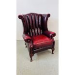 A CHESTERFIELD WING BACKED ARM CHAIR IN OXBLOOD RED FINISH - TRADE ONLY
