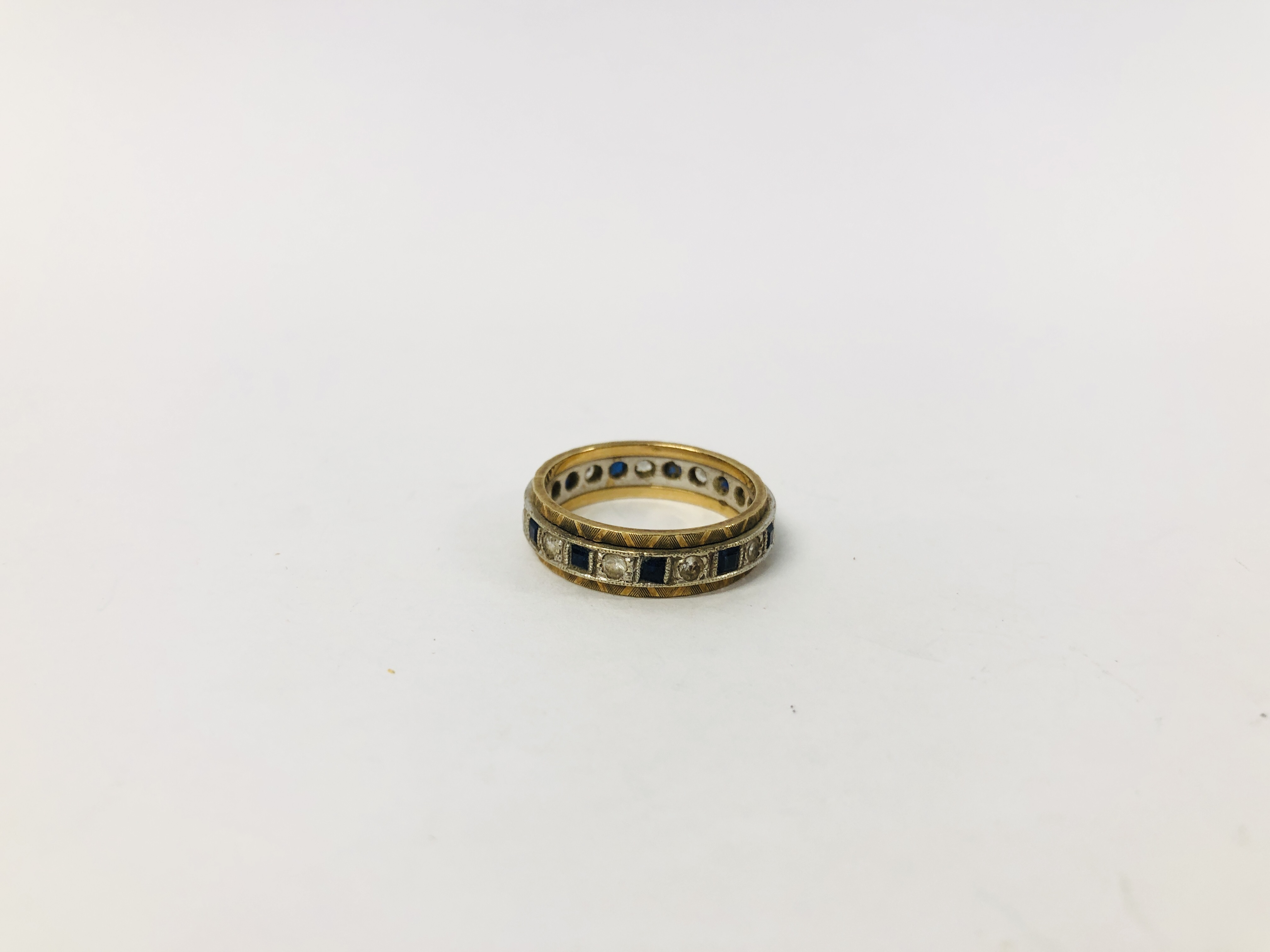 A 9CT. GOLD ETERNITY RING SET WITH ALTERNATE BLUE AND WHITE STONES.